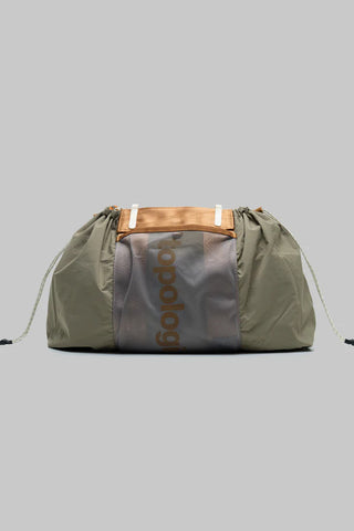 Olive green tote with drawstring top, two side cords, and interior logo patch.