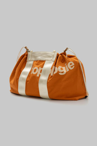 Orange and white striped tote with drawstring opening and metal D-ring top handles.