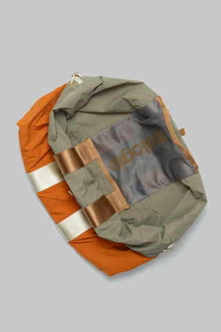 Olive and burn-orange striped tote with drawstring closure and gold webbing trim.