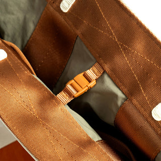 Interior organizer in rust-brown with stitched panels and adjustable snap webbing strap.