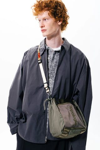 Gray/olive crossbody sling pouch with adjustable strap and side pockets