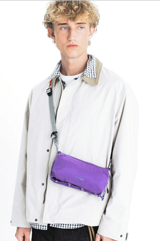 Worn utility sling bag with purple body and crossbody strap