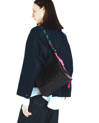 Black utility sling crossbody with pink strap and teal trim