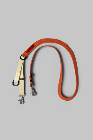 Topologie utility sling bag in orange with adjustable strap and metal clips