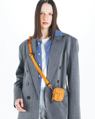 Topologie utility sling bag, orange crossbody worn with adjustable strap and buckle