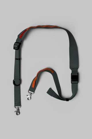 Utility sling bag with dark gray strap and orange trim, metal clasps and adjuster