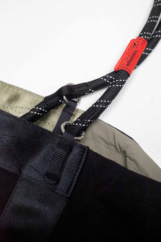 Nylon loop strap with metal rings and red label on dark webbing
