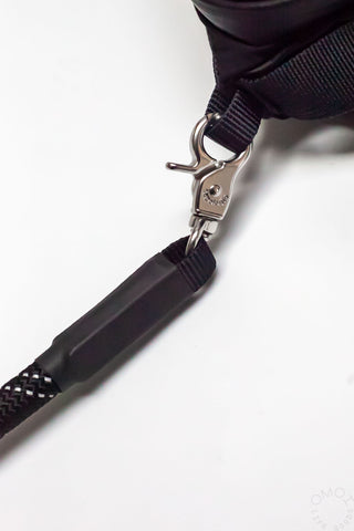 Black rope strap detail with metal spring clip and textured webbing