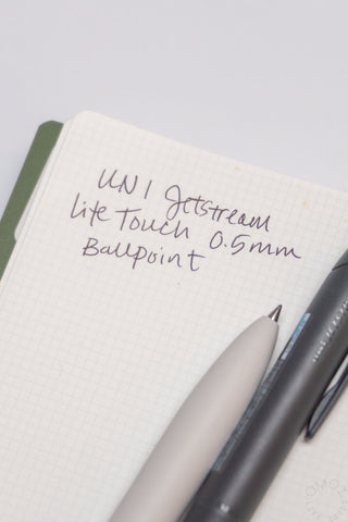 0.5mm lite touch ink refill writing on grid notebook with dark pen tip