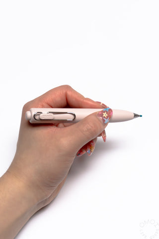 Uni-Ball One P gel pen with peach barrel held in hand, chrome clip and black tip