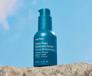 Teal Forest Water Hyaluronic Serum bottle with pump standing on rock