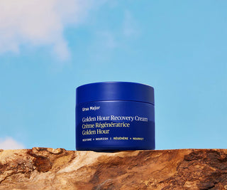 Blue recovery cream jar on a textured surface.