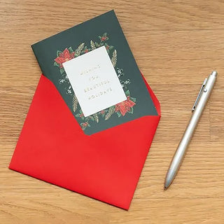Green pop-up Christmas card with poinsettia wreath, with red envelope and pen