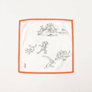 White cleaning cloth with orange border featuring multiple black animal figures.