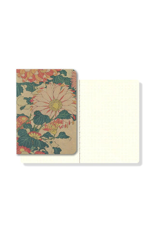 Pocket notebook open to blank pages, showing floral chrysanthemum cover and hinge