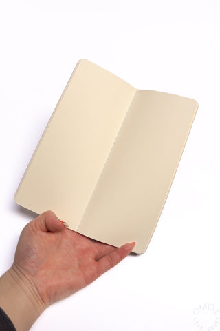 Blank notebook opened to cream pages with smooth, unlined paper