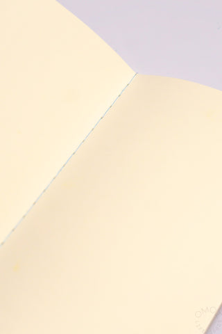 Close-up of cream notebook pages with thin crease along the spine
