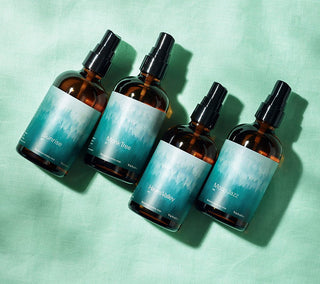 Set of amber botanical aroma mist bottles with black mist sprayers and blue-toned labels
