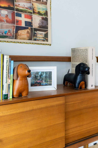 Tan dachshund bookend in leather-look, standing on four legs on a shelf