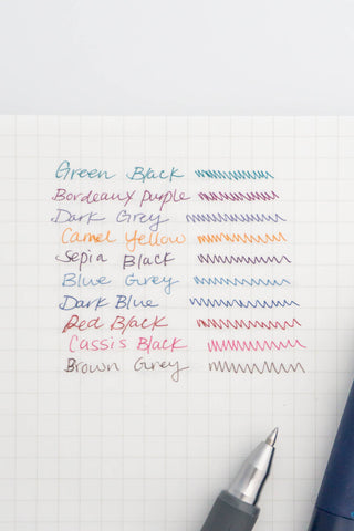Gel ink color samples on grid paper with pen nib visible