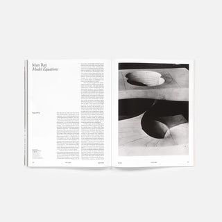 Open magazine spread with 'Man Ray' text and monochrome abstract artwork