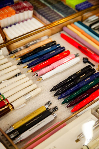 Image of various pens and writing tools in a display case