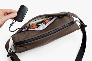 Brown crossbody sling bag with front zipper and hanging key fob loop.