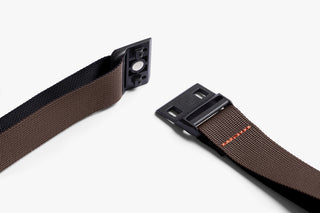 Crossbody strap hardware with buckle and clip connector on a dark webbing base.