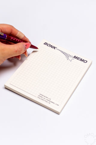 Hand writing on beige grid memo pad with BONK MEMO header and green star outline