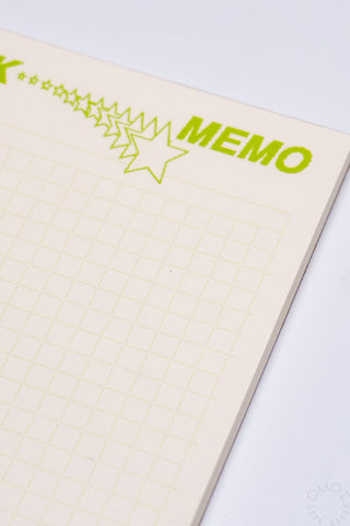Close-up of green-accent header on a beige grid memo pad, with star and MEMO text