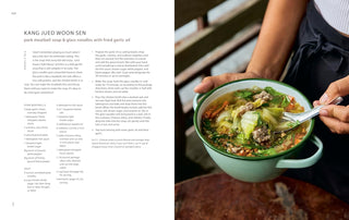 Cookbook open spread with green pot of noodle soup held by a person