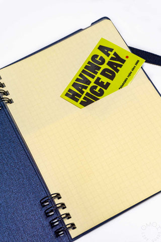 Navy spiral notebook with cream grid pages and neon label on sheet cover