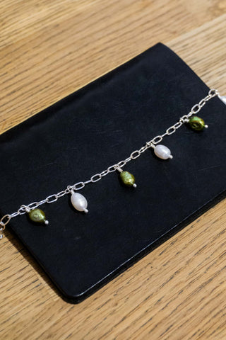 Silver-plated bracelet with three dangling charms: pearl-like drops and green beads