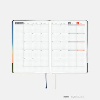 A6 planner open to month calendar grid with orange date highlights