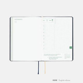 Hobonichi HON A6 slash planner open to calendar pages, English edition, with ribbon ties