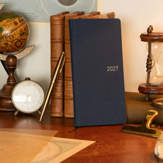 Midnight blue 2027 planner standing with elastic ties and gold “2027”