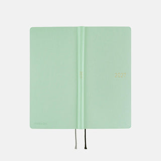 Open 2027 planner showing spine and pages, jade green cover, black ribbon ties