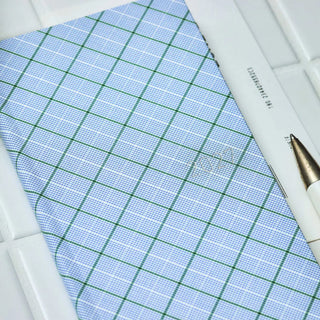 Close-up of blue-green plaid planner cover corner with grid lines and stitched edge