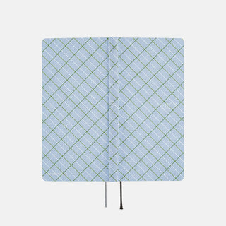 Open planner spread showing two graph paper pages with vertical seam and tie strings