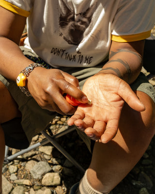 SPF 30 sun cream tube with orange tip, applying cream to skin