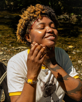 SPF 30 daily sun cream applied to face with hands outdoors