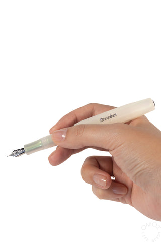 Light green fountain pen held in hand, medium nib tip visible