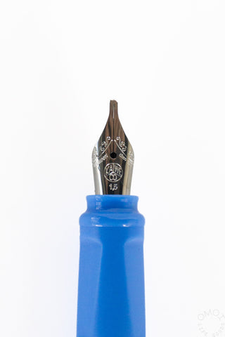 Close-up of a blue ink reservoir cartridge and metal calligraphy fountain pen nib