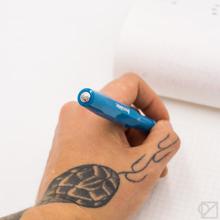 Cyan Kaweco Sport fountain pen held in hand with nib at tip