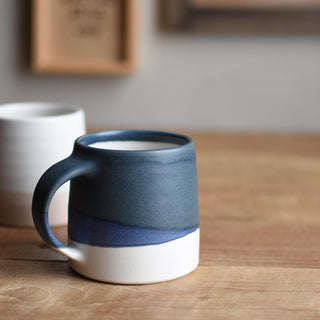 Navy and white ceramic mug, side view with curved handle and glossy rim