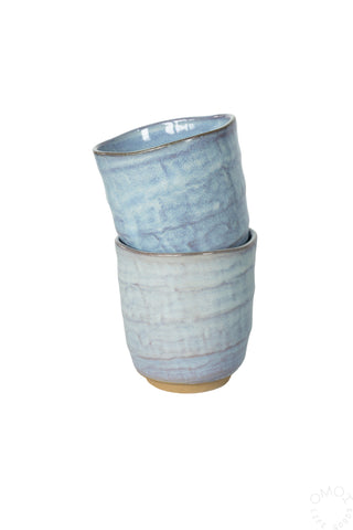 Light blue textured ceramic teacup stack-style view, dark inner rim