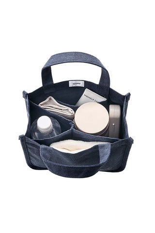 Navy canvas tool tote open view with organizers and visible bottle and round kit case.