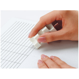 Corner eraser held by hands removing pencil marks from graph paper