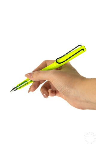 Neon yellow LAMY Safari fountain pen held in hand, nib tip visible