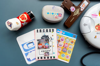 Lucky bears sticker sheets with bear and icon designs laid out on a blue surface